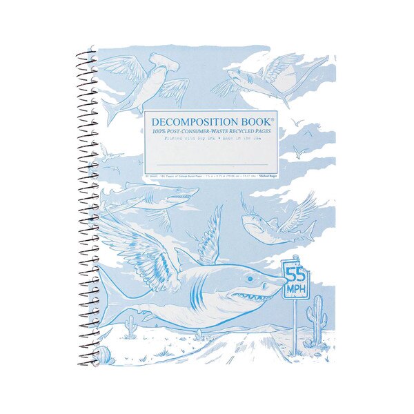This is a spiral bound composition book. The text on the cover is blue. The cover is white with fun drawings of different shark varieties with wings flying across the desert.