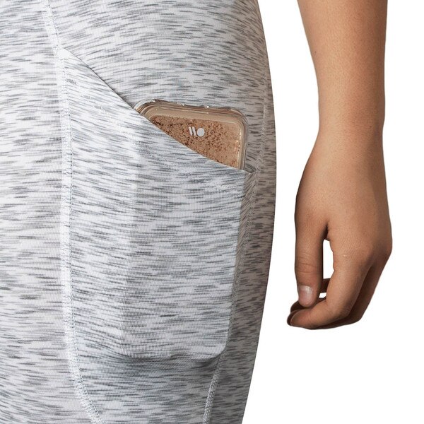 A close up look at the side pocket of gray leggings that hold a phone inside.