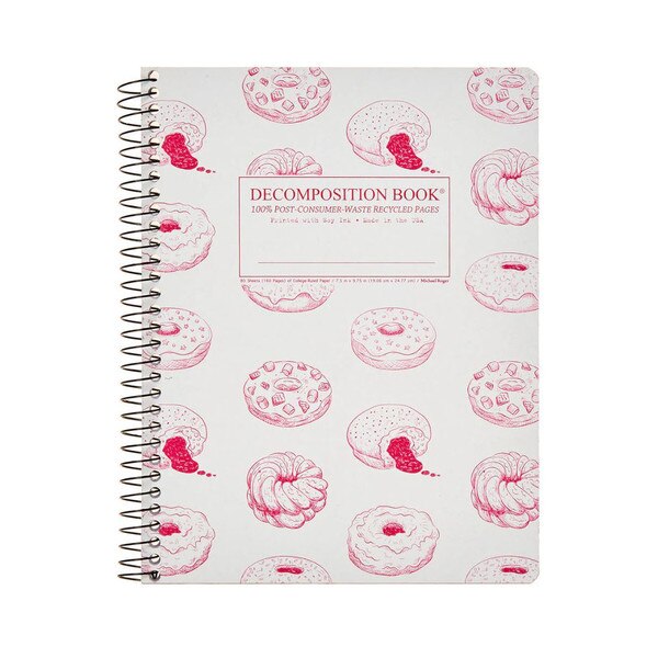 This is a Decomposition branded spiral bound composition book. The text on the cover is red. The cover has multiple drawings of donuts in a repeating pattern in red over a white background.