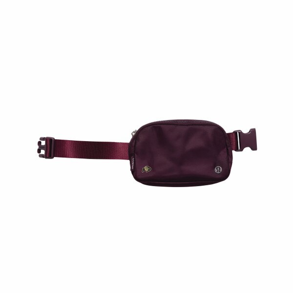 A maroon belt bag with a C-U buffalo logo on bottom left and a metal lululemon logo on the bottom right.