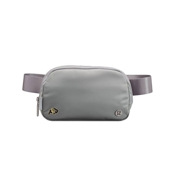 A silver belt bag with a C-U buffalo logo on bottom left and a metal lululemon logo on the bottom right