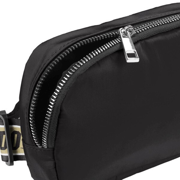 The corner of the black crossbody bag, showing the main zippered pocket.