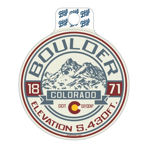 This is a white sticker with grey blue and deep red details. Boulder is arched over top and the elevation is stated on the bottom. There are mountains in the background behind the Colorado sign.