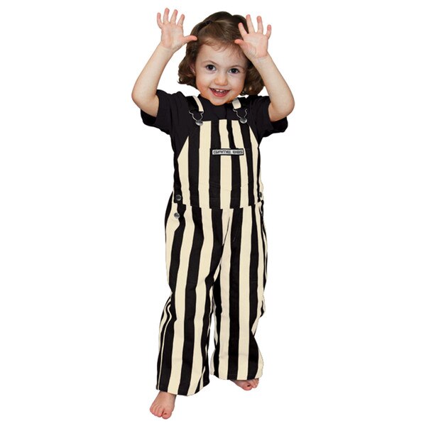 This is a pair of full length toddler overalls. They are striped black and gold vertically. A very cute toddler is modeling them.