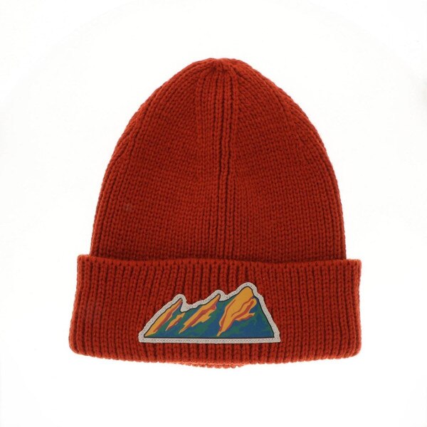 This is a Copper orange beanie with a small patch on the front of the cuff. The flatirons patch is green, blue, orange, and red. The design of the mountains is lined with a beige border.