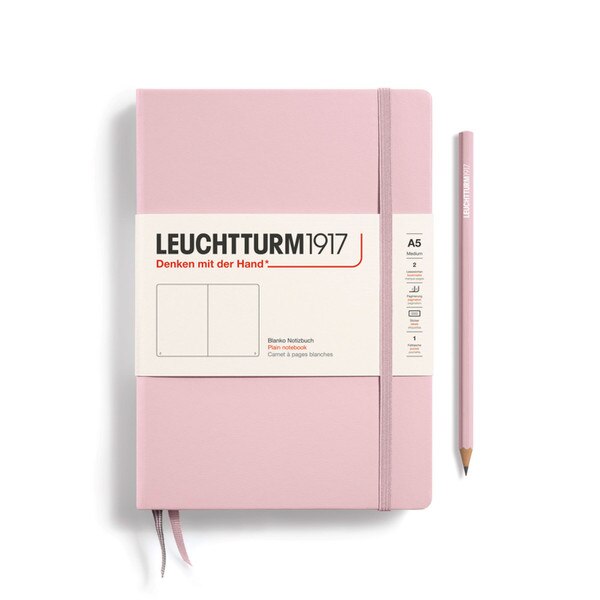 A powder (pale pink) colored hardcover notebook.