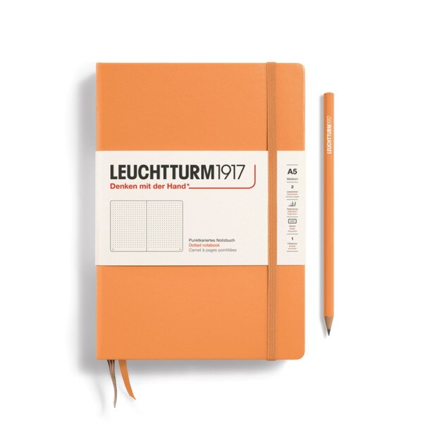 Apricot hardcover dotted notebook with closure strap and two bookmarks.