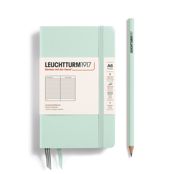 A mint colored hardcover notebook with an elastic to keep it closed.