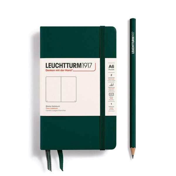 This is a small, deep green notebook with an elastic and two bookmarks. The pages are blank other than page numbers in the bottom corners.