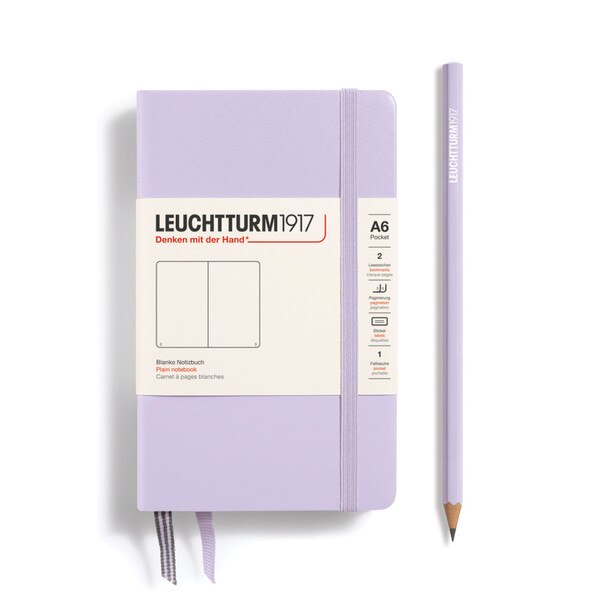 This is a small, light purple notebook with an elastic and two bookmarks. The pages are blank other than page numbers in the bottom corners.