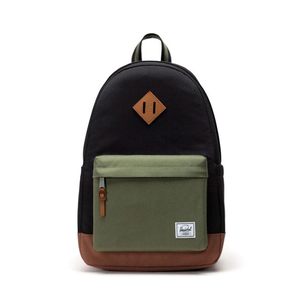 Black backpack with brown leather accents on center, zipper, and bottom, with Herschel logo patch on small zipper pocket which is a light green color..