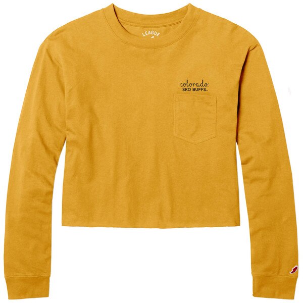 This is a gold, long sleeved cropped tee shirt. The left chest pocket is the same color as the shirt. The words on top of the pocket are on top of each other and black.