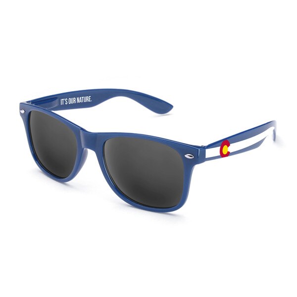 This is a pair of Blue sunglasses with black lenses. Each arm is adorned with a small Colorado flag by the top. A long white stripe runs down the length of each arm.