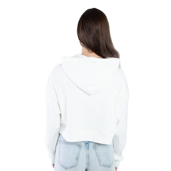 Back view of a woman wearing a white cropped hoodie with ridged texture and a relaxed hood, paired with light-wash jeans.