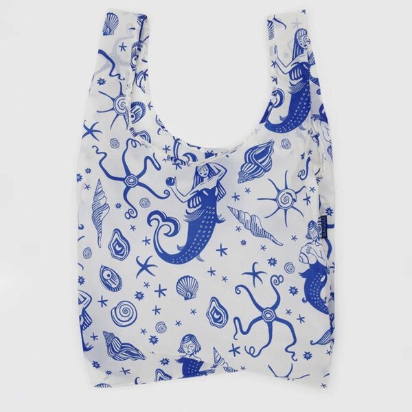 White reusable BAGGU bag with allover blue mermaids, sea creatures, and shell illustrations