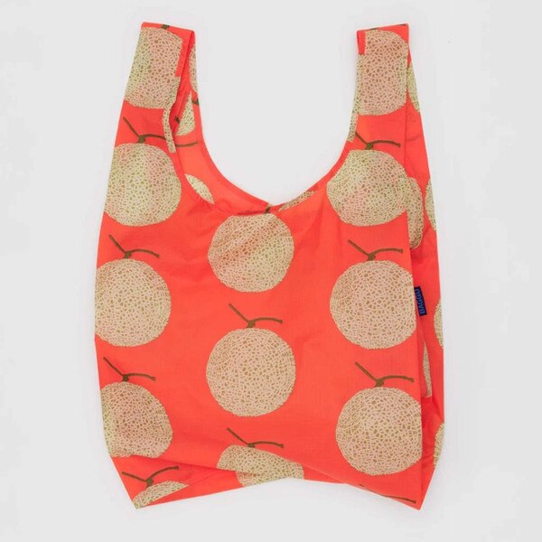 Bright orange reusable BAGGU bag with allover whole cantaloupe fruit print and blue logo tag