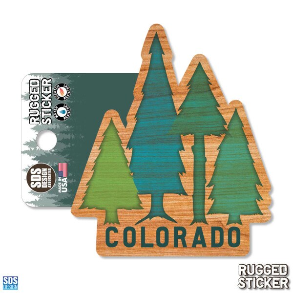 Colorado rugged sticker featuring a group of stylized evergreen trees with a woodgrain background and "COLORADO" printed below.