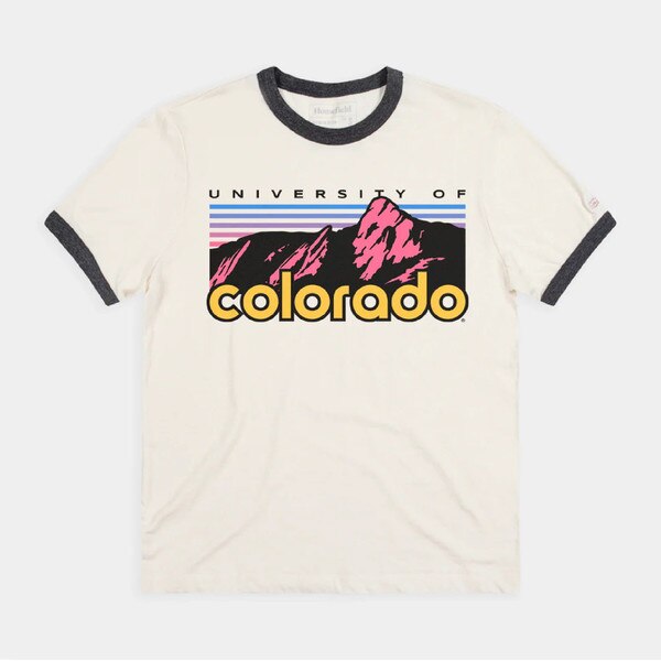 Cream CU Boulder ringer T-shirt with contrasting black collar and sleeve cuffs, featuring a bold Flatirons graphic in pink and purple with “University of Colorado” text.